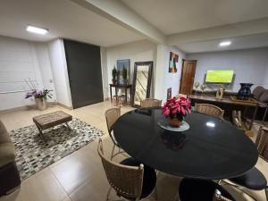 a dining room with a black table and chairs at Excelente Casa para 10 pessoas proximo ao Shopping Flamboyant- Serra Dourada-Autódromo in Goiânia