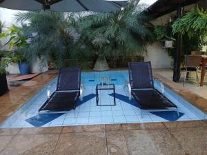 two chairs and a table in a swimming pool at Excelente Casa para 10 pessoas proximo ao Shopping Flamboyant- Serra Dourada-Autódromo in Goiânia