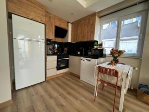 a kitchen with a table and a white refrigerator at Chic 2BR City Center Flat in Antalya