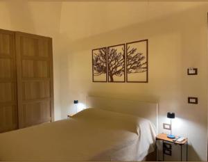 a bedroom with a bed with two trees on the wall at GAPO Rooms in Orta Nova