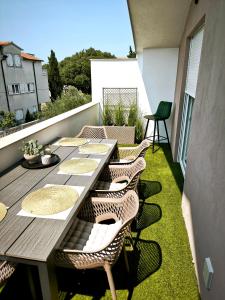 a table and chairs on a balcony with grass at Artistik in Vodice