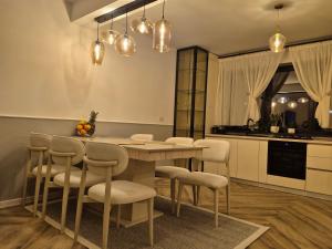 a kitchen with a dining room table and chairs at Del House in Zărneşti +6 photos