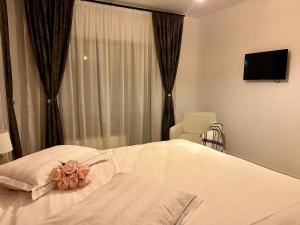 a white bed in a room with a window at Del House in Zărneşti