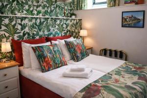 a bedroom with a bed with a pile of pillows at Hotel Tre Små Rum in Stockholm