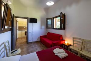 a room with a red bed and a red couch at Casa Priora vista Sibillini in Montefortino