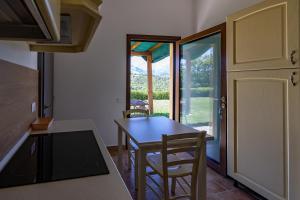 a kitchen with a table and chairs and a door at Casa Priora vista Sibillini in Montefortino