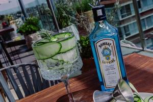 a bottle of gin next to a glass with a drink at Kasa Hotel & Suites in Irapuato