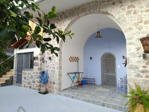 an archway leading to a house with a door at Sadarmis Houses in Leonidio