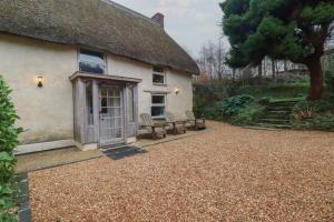 a cottage with two chairs in front of it at Plenteth in Truro