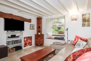 a living room with a couch and a tv at Plenteth in Truro