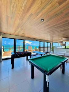 a pool table in a room with windows at Maré Alta Beach Hall by AFT in Tamandaré
