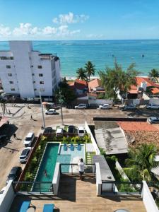 an aerial view of a resort with a swimming pool and the ocean at Maré Alta Beach Hall by AFT in Tamandaré