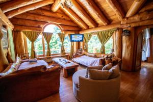 a living room with couches and a tv in a cabin at Rotui Luxury Village in San Martín de los Andes