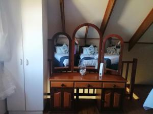 a bedroom with two beds and a table with a mirror at Forest Hill Accomodation in Port Alfred