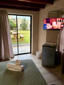 a room with a large window and a tv on the wall at Forest Hill Accomodation in Port Alfred