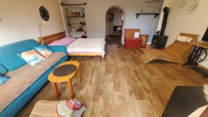 a living room with a blue couch and wooden floors at TUTTO Home in Frýdlant nad Ostravicí