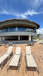 a group of chairs and tables in front of a building at Casa Marimar Milagres- Praia do Marceneiro in Passo de Camarajibe