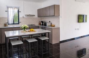 a kitchen with a island with bar stools at D'eaU BleU Villa-Private pool in Pereybere