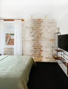 a bedroom with a brick wall and a bed at Golden View - Old town apartment in Rovinj