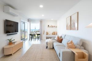 a living room with a couch and a tv at The Nook in Aldinga Beach