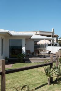 a house with a fence and an umbrella at The Nook in Aldinga Beach
