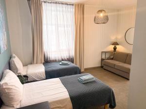 a hotel room with two beds and a couch at Zeit Apartments in Līgatne