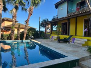 a house with a swimming pool in front of a house at Micas House in Ilhabela