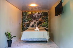 a bedroom with a waterfall mural on the wall at Kibutz Eco Guesthouse in Fortuna