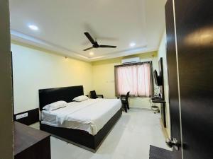 a bedroom with a bed and a ceiling fan at The Royal Comforts in Visakhapatnam
