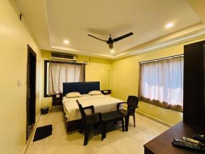 a bedroom with a bed and a table and chairs at The Royal Comforts in Visakhapatnam