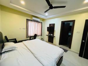 a bedroom with a bed and a ceiling fan at The Royal Comforts in Visakhapatnam +1 photo