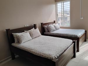 a bedroom with two beds and a window at Chateau de Mankosah in Accra