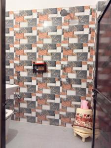 a bathroom with a mosaic tile wall at Shree Rameshth Homestay in Ayodhya +25 photos