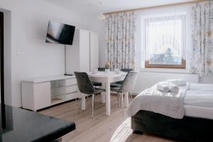 a white room with a table and chairs and a bed at Apartamenty Pienińska Aura in Czorsztyn