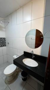 a bathroom with a toilet and a sink and a mirror at Riacho Hotel in Brasília +137 photos