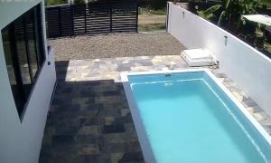 a swimming pool on the side of a house at D'eaU BleU Villa-Private pool in Pereybere +1 photo