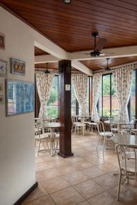 a dining room with tables and chairs and windows at Bella Pousada in Abraão