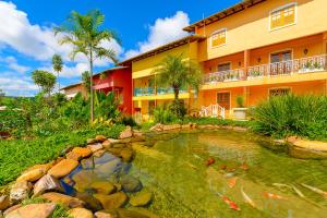a hotel with a pond in front of a building at Pousada dos Pireneus in Pirenópolis