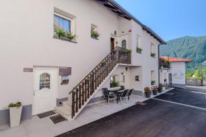 a building with a staircase and a table and chairs at Penzion Hosnar, Apartment Mišc in Bovec