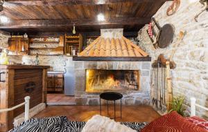 a living room with a stone fireplace in a kitchen at Old Oak Villa-house with Private Pool, Authentic Tavern & BBQ in Hrvace