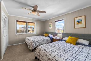 a bedroom with two beds and a ceiling fan at Beachfront Villa Royale OBX in Avon +40 photos