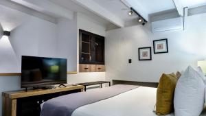 a bedroom with a bed and a flat screen tv at Casa Solsticio 212 in Cholula