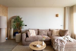a living room with a couch and a table at Casa Amare in Egmond aan Zee