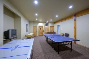 a room with two ping pong tables and a tv at Powder Mtn Retreat MH110 Near Powder Mtn Hot Tub in Eden