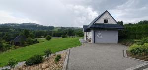 a small white building with a pitched roof at Grey House Istebna in Istebna