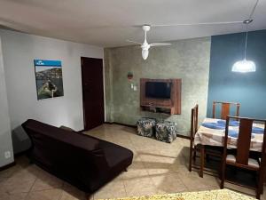 a living room with a bed and a tv at Kitnet Aurora in Miguel Pereira