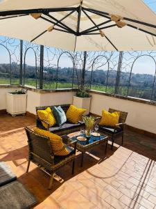 a patio with a couch and chairs and an umbrella at Bencivenga Terrace in Rome