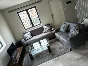 a living room with a couch and a table at Coastal Guest House with Free Parking and Braai Area in Cape Town