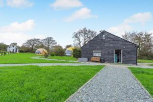a black house with a gravel driveway and grass at 1 Bed in Redberth oc-s33669 in Redberth