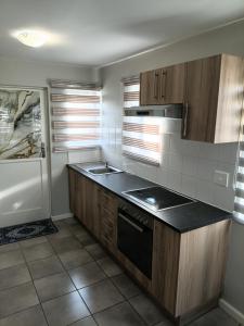 a kitchen with wooden cabinets and a black counter top at Coastal Guest House with Free Parking and Braai Area in Cape Town +9 photos